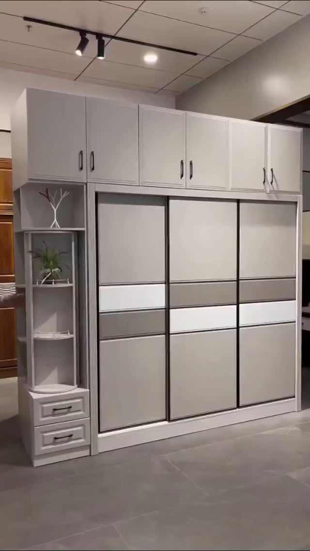 A large grey and white sliding door wardrobe with integrated shelving and upper cabinets.