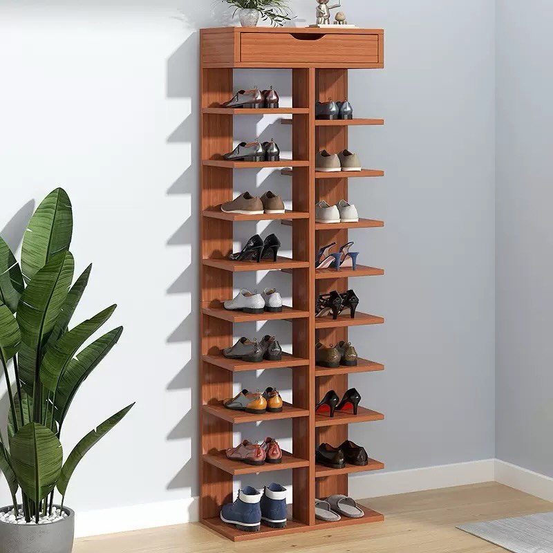 A tall wooden shoe rack filled with various pairs of shoes against a white wall.